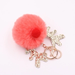 Close-up of red fluffy elk keychain with golden glitter antlers and rose gold clasp
