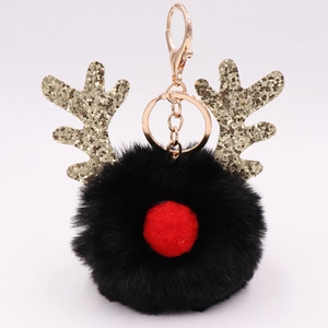 Detail of reindeer plush keychain with black fur ball, red nose and gold glitter antlers