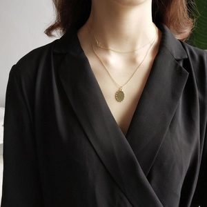 Double-layered 925 sterling silver golden necklace with brushed oval pendant on model