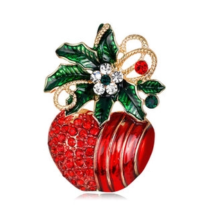Macro view of strawberry brooch with red stripes, green holly leaves and crystals