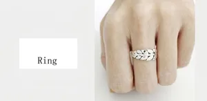 Close-up of a silver ring featuring a detailed layered feather and leaf pattern design