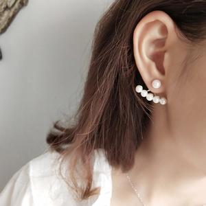 925 silver fan-shaped earrings with five gradient pearls on a model earlobe