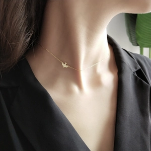Minimalist 925 sterling silver bird pendant necklace with gold finish on black outfit