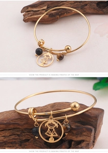 Détail du bracelet doré ajustable avec pendentif fille, pierre de lave et oeil de tigre