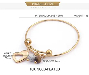 Détail d'un bracelet doré avec pendentif coeur et perles marbrées de 68mm de diamètre
