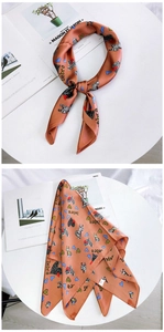 Detailed view of square silk scarf with zebra and leopard heart patterns in warm orange tones