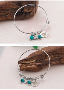Detail of silver bangle with turquoise bead, heart charm, and Happy Mother's Day tag