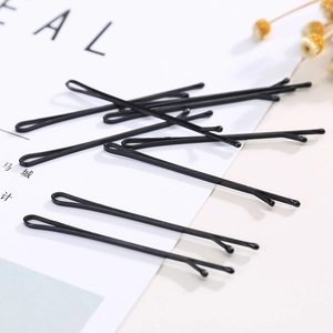 Minimalist black metal hair pins with rounded protective tips shown on a white card