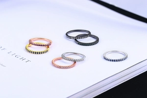 Close-up of stacked zircon rose gold and silver rings on an open book page