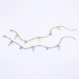 Minimalist key charm anklet set in gold and silver finish on a clean white background