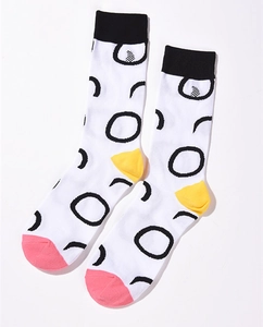 Detail of white cotton crew socks featuring black rings with yellow and pink contrast panels