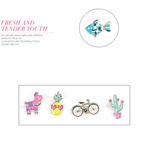 Detailed macro view of colorful metal enamel pins including cactus and flamingo designs