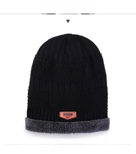 Detail of knitted winter beanie showing striped pattern, faux fur lining and leather patch