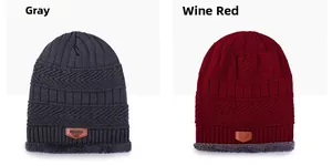 Close-up of grey and wine red knit beanies with warm fleece lining and leather patch