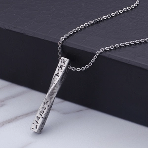 Collier pour homme avec pendentif barre torsadée en acier inoxydable argenté sur marbre