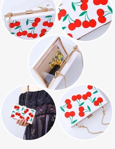 Detailed view of white acrylic cherry clutch with gold chain and interior capacity
