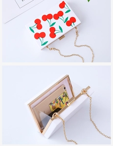 Internal capacity of cherry print acrylic evening clutch with gold chain and iPhone