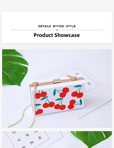 Detailed view of white acrylic clutch featuring cherry prints and gold metal chain