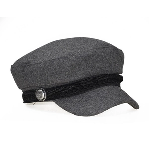 Detailed close-up of dark grey wool newsboy cap featuring braided strap and crown metal button