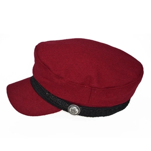 Close-up of burgundy wool newsboy cap featuring black braid trim and silver crown button