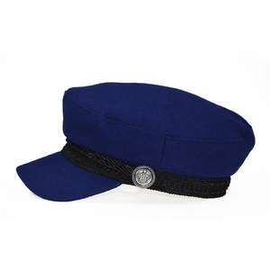 Detail of navy wool baker boy hat with black braided rope and silver crown button