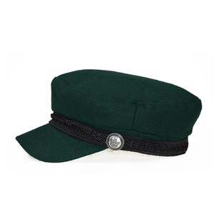 Detailed view of the dark green wool newsboy hat with crown embossed silver button