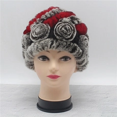 Close-up of winter fur hat with tricolor stitching and 3D floral accent on mannequin