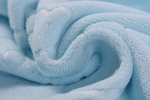 Macro detail of soft light blue microfiber towel showing plush texture and absorbent fibers