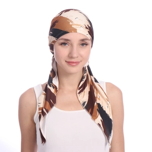 Detailed close-up of a women's patterned turban hat with stylish abstract brown prints