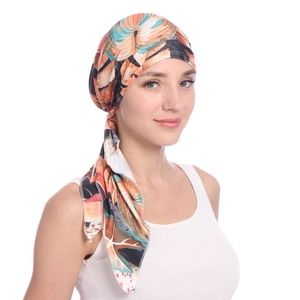 Detail of vibrant orange and blue leaf print pattern on soft milk silk headscarf cap