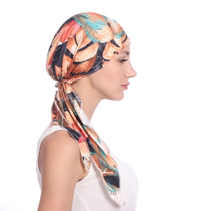 Side view of multi-color tropical leaf print turban hat with stylish side ruching detail