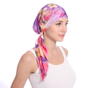 Detail of silk floral headwrap with purple gradient flower pattern on female model