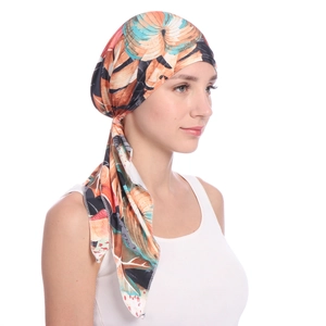 Detail view of floral printed turban hat with tropical leaf pattern on model side profile
