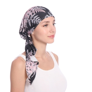 Detail of elegant pink leaf pattern on black headscarf showing back tie and drape