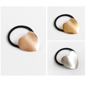 Detail of metallic heart hair ties in rose gold, gold, and silver finishes with elastic bands
