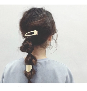Golden geometric metal heart hair clip and hollow rectangle slide on braided hair