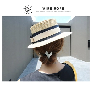 Detail view of a V-shaped alloy hair tie with a wire drawing finish on a model ponytail