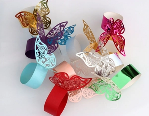 Macro shot of colorful laser-cut butterfly napkin rings with metallic finish on white
