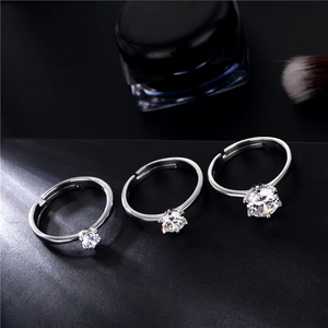 Three classic six-prong silver rings with sparkling cubic zirconia on a dark background