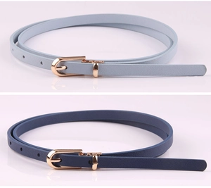 Detail of light and dark blue faux leather skinny belts with golden pin buckles