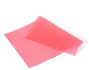 Detail view of pink honeycomb silicone cabinet mat with non-slip texture for drawers