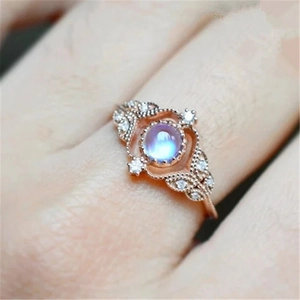 Vintage-Ring in Roségold mit Mondstein und Zirkonen an der Hand eines Modells