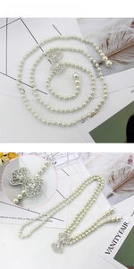 Détail de la ceinture en perles avec boucle en forme de nœud sertie de strass argentés