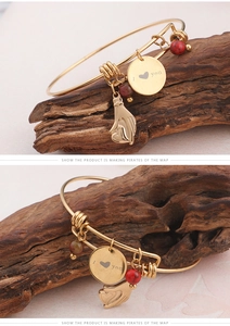 Golden crescent heart charm bracelet with I Love You engraved tag on wooden stand