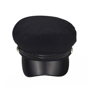 Detail of black newsboy cap with textured twill, woven rope, and silver metal buttons