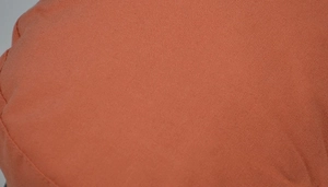 Macro view of brick red navy cap fabric showing thick cotton texture and fine weaving