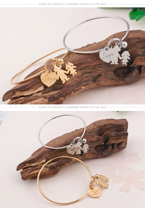 Détail des breloques cœur or et argent avec gravure Love et pendentif silhouette élégant