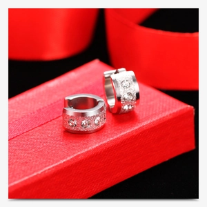 Detail of 18K gold 7mm frosted hoop earrings with cubic zirconia on red silk