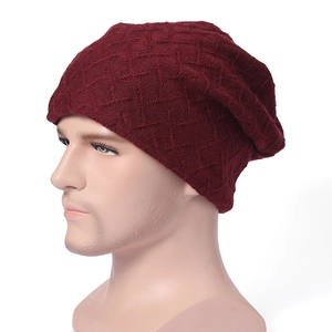 Dettaglio del berretto in maglia rosso vino con texture traspirante a rombi