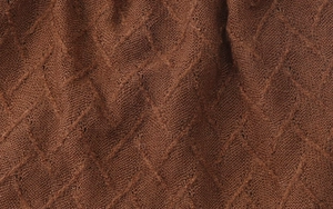 Macro di tessuto a maglia marrone scuro con trama geometrica a rombi molto dettagliata
